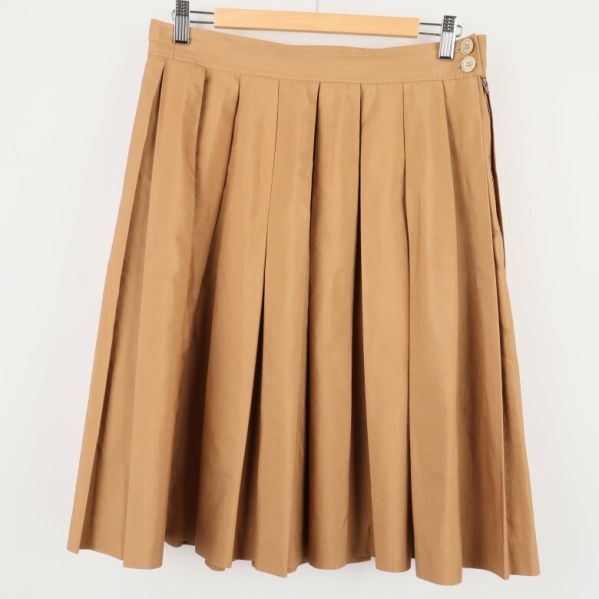 Framsida av beige plisserad kjol med knappar