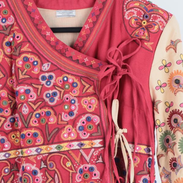 Detaljerat broderi och knytband på bröstet
