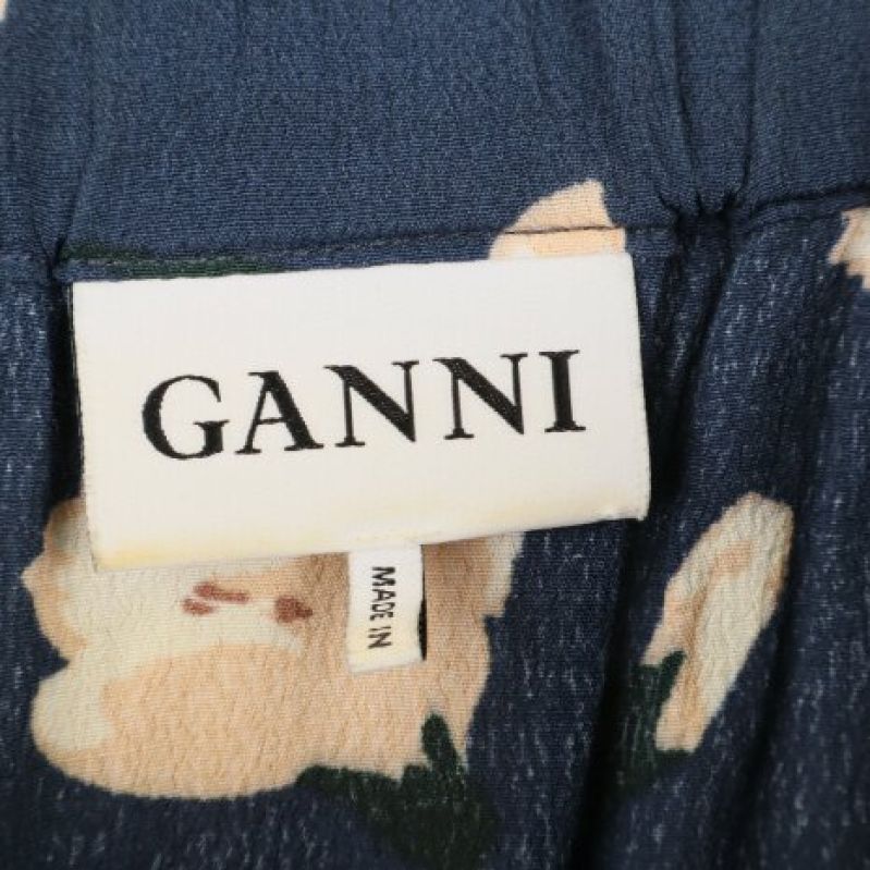 Närbild av Ganni-märke på blommig kjol