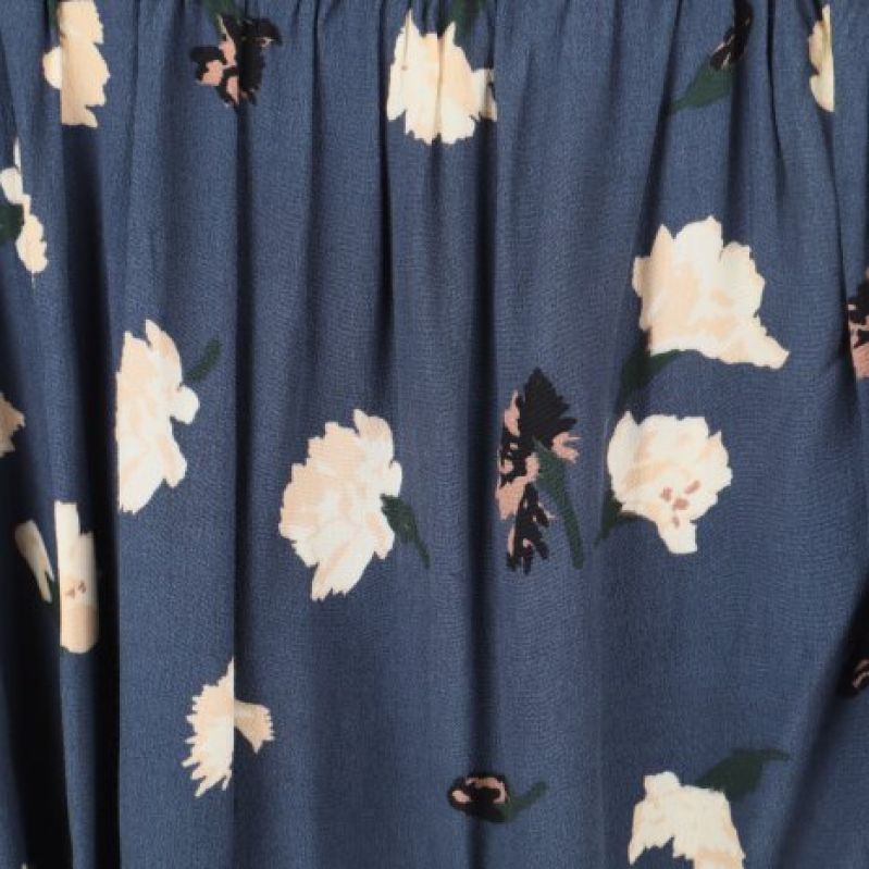 Detaljerad bild av blommigt mönster på blå kjol
