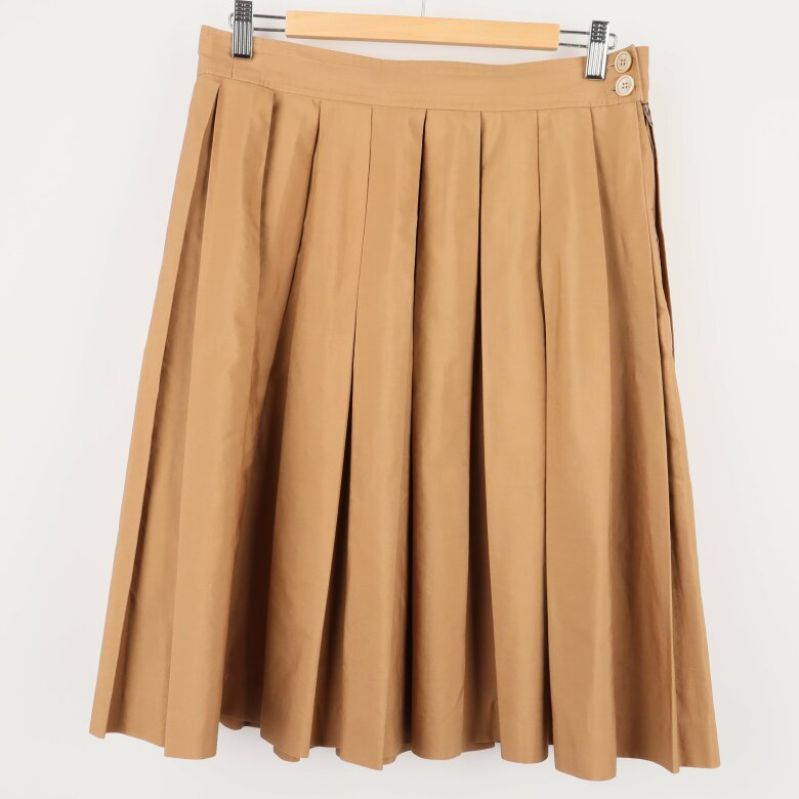 Framsida av beige plisserad kjol med knappar