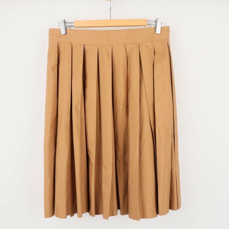 Baksida av beige plisserad kjol